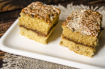Sliced  biscuit cakes from  nuts and sesame seeds on a white porcelain plate
