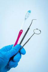 Gloved hand with dental instrument