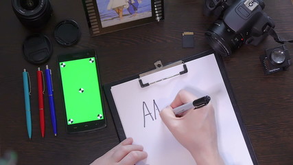 A man writes a pen on paper word answer