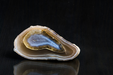 Beautiful blue agate slice on a black mirror table