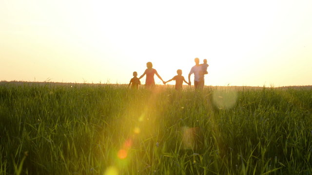 Happy young family with children  running around the field