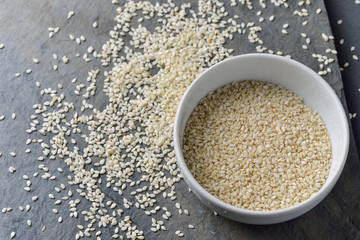 sesame seeds in bowl on rock background