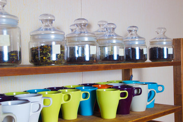 colorful cups and a lot of varieties of tea on the shelves