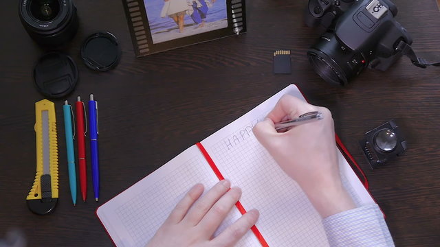 A man writes smile a pen in notebook - Powered by Adobe