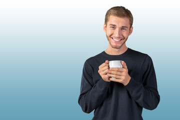 Young handsome man holding warm cup of tea/coffee