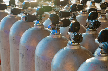 Line of scuba diving air tanks, flared image with soft focus