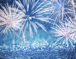 Defocused blue fireworks and glitter at New Year and copy space. Abstract background holiday.