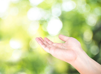 Open hand with blur nature green bokeh background