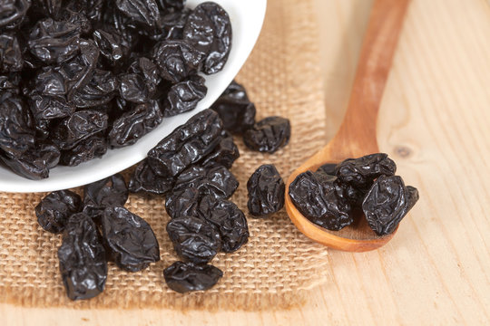 Raisin in the bowl on the wood background