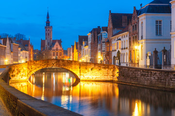 Scenic night cityscape with views of Spiegelrei, Canal Spiegel, bridge and church in Bruges, Belgium