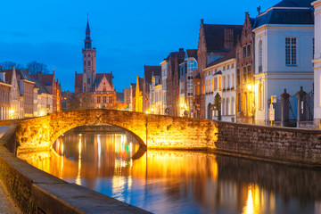 Fototapeta na wymiar Scenic night cityscape with views of Spiegelrei, Canal Spiegel, bridge and church in Bruges, Belgium
