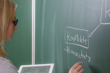 schülerin schreibt auf der tafel