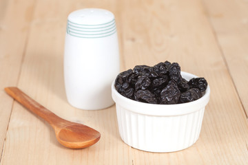 Raisin in the bowl on the wood background