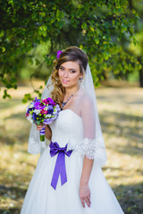 The girl in a wedding dress with purple bow
