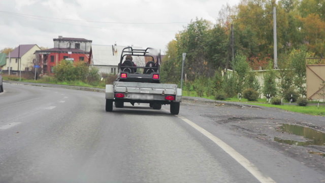 Car with a trailer traveling on the road