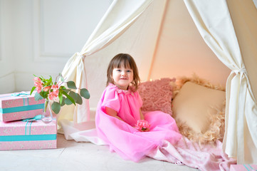 Obraz na płótnie Canvas Little girl in pink dress near wigwam