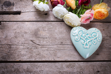 Bright flowers and  decorative heart  on vintage  wooden backgro