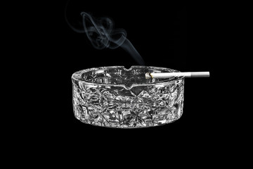 Glass ashtray with a cigarette