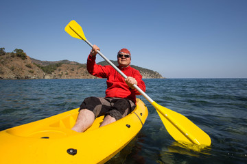 Young caucasian man kayaking in sea at Maldives