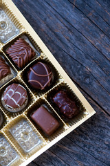 Different types of chocolate candies on a wooden background