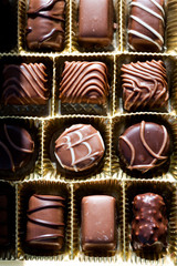 Different types of chocolate candies on a wooden background