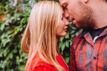 Fototapeta premium Young man and woman on the nature. Playful couple in love. Woman if red dress. Man in red shirt