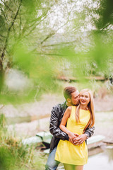 Young man and woman on the nature near lake and forest. Playful couple in love