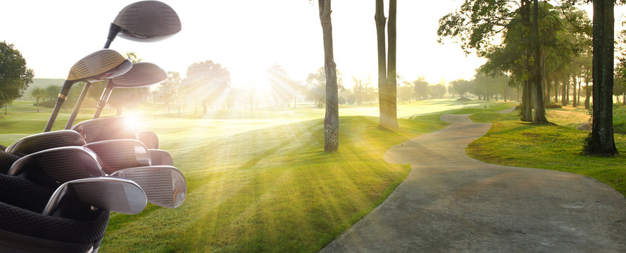 Golf clubs drivers over  beautiful golf course at the sunset, sunrise time.