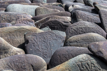 Carved Buddhist Mani Stones near Thiksay Monastery, Leh, Ladakh. Mani stones are rocks inscribed...