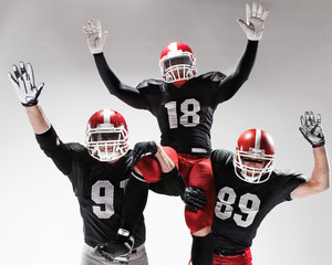 The three american football players posing on white background