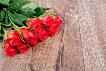 Fototapeta na wymiar Red roses on a wooden background