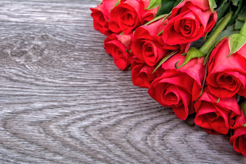 Red roses on a wooden background