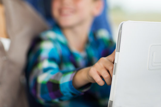 close up of boy with tablet pc in travel bus