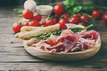 Antipasto with ham and green asparagus