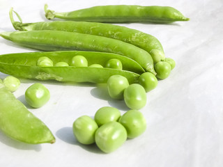 Green Peas and pea fruit the legume on white.