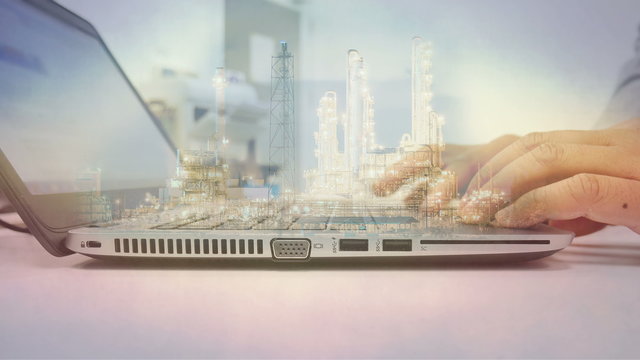 Double exposure scene of engineer working computer laptop with refinery plant on night time
