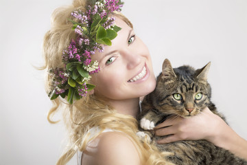 Frau mit Blumen im Haar und Katze auf dem Arm