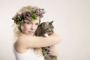 Frau mit Blumen im Haar und Katze auf dem Arm