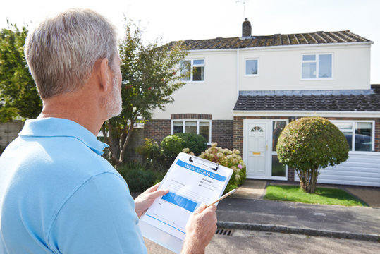 Builder Preparing Estimate For Exterior Home Improvement