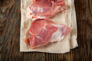 Raw pork chop steak on wooden cutting board.