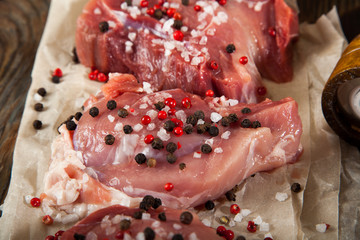 Top view raw pork chop steak and garlic, pepper on wooden background.