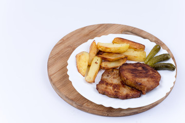 Fresh fried french fries with pork chops and pickled cucumbers