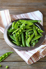 fresh green peas on metal plate