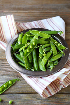 fresh green peas on metal plate