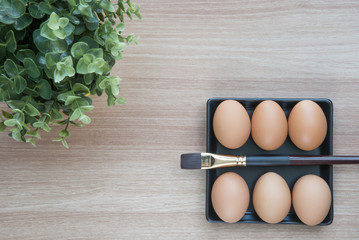 Selective focus of six Eggs in black square plate with a brush