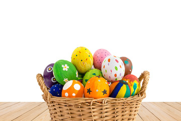 Fototapeta na wymiar Colorful Easter eggs in a basket on wood texture isolated on whi