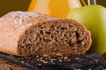 Piece of bread with on black stone with apple