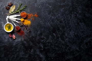 Zelfklevend Fotobehang Herbs and spices over black stone © karandaev