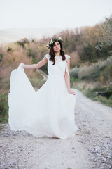 Fototapeta na wymiar portrait of bohemian bride in nature, with white dress and crown
