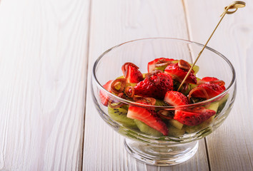 Salad with strawberries, kiwi, spinach.